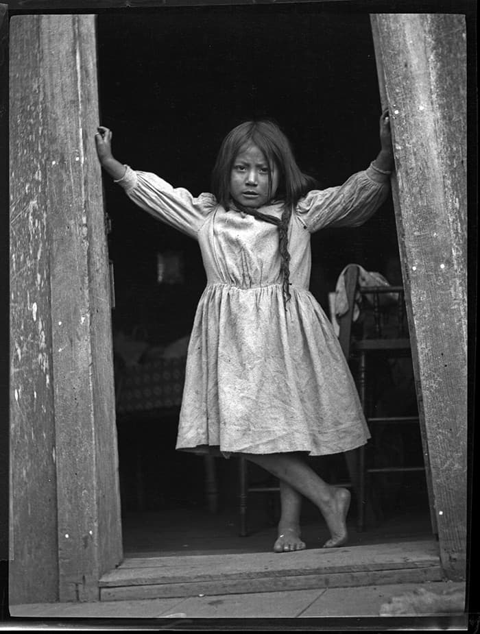 Photograph of little girl in doorframe from ca. 1910