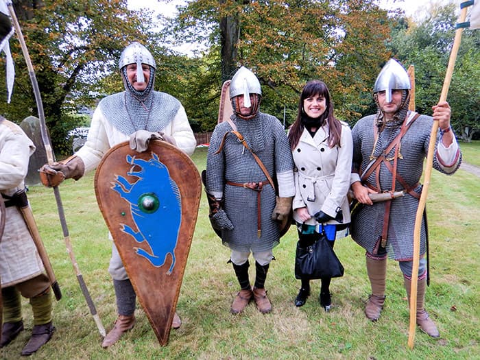 Medieval manuscripts curator Vanessa Wilkie in Battle, England, standing with visitors from France dressed as Norman soldiers