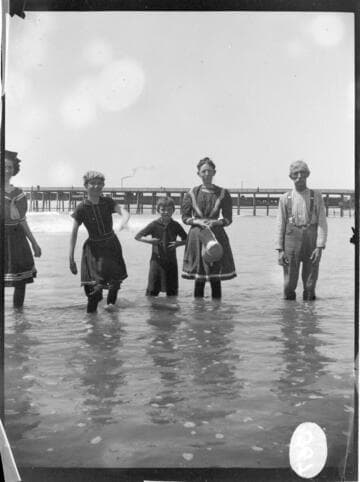 B.F. Pearson's family wading in the water at the beach