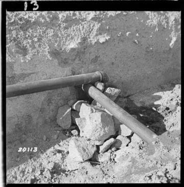 Photo showing outlet of 4" drain from the two weepers in rock chimney built up under weeper at Easterly end of 11th