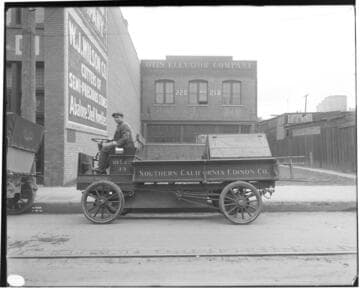 A man driving Electric Truck #33, showing the Otis Elevator Company and the W.J. Wilson Co