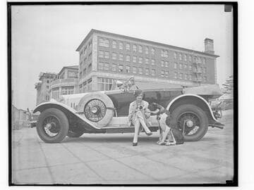 Woman and dog with car in front of the Club Casa del Mar, Santa Monica, California