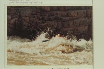 Dock Marston in the rough of 217 Mile Rapid as he drives a Yak loaded with a 35mm motion picture camera