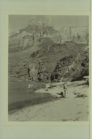 Camp at foot of Tanner Trail.  The "Esmeralda II" is moored beyond the drift.  Bestor Robinson watches the fire