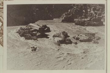 Bureau of Reclamation aluminum barge on the bedrock in Bedrock Rapid where it hung after getting loose at Lees Ferry.  The scow moved to Mile 193, left bank, in 1948