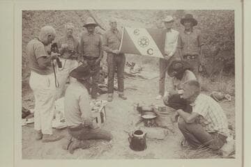 The inevitable Explorers Club flag.  At camp in middle fork of 73.6.  Kneeling:  Buster Ordiway; Dan Lehi; Chris Turner.  Standing:  Dock Marston; Josh Eisaman; Buck Whitehat; Archeyes Masland; Tom Daly; Tobe Owl