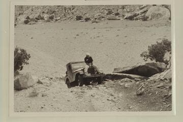 Marston rides the hool of Kent Frost's jeep.  Needles country, Utah.  [enlargement of V007/0072.01]