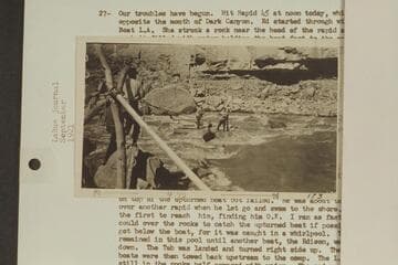 USGS boat on rocks in Dark Canyon Rapid. Lint is on shore and Emery and Ellsworth on the boat. LaRue Colorado River album #173