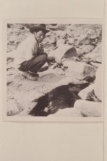 Bahe examines the clear and the black water in Black Water Creek just below Black Water Cave.  North side of Navajo Mountain