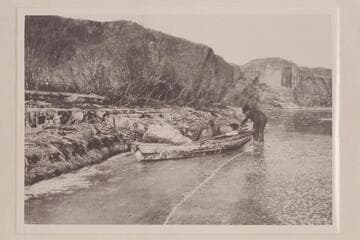 John Wetherill preparing to drag boat across shore ice