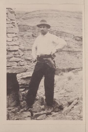 E. R. Spencer at Mendenhall cabin.  The front of the print states:  E. E. S. 1915 the only thing the Indians left of a camp was the fire place and a cabin in #2.  #2 is copied on 15 SJRR 110.9 [V125/0028]