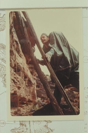 Bill Mooz climbing the poles to the monument, Mile 116.35