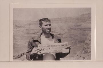 Bill Beer holding news account of the loss of Daggett and himself.  South Rim