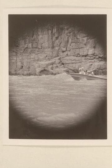 Brian Rowlands piloting the "Rattlesnake" through 217 Mile Rapid.  Mert Ingham sits aft on the port side and John Schulz is next to him