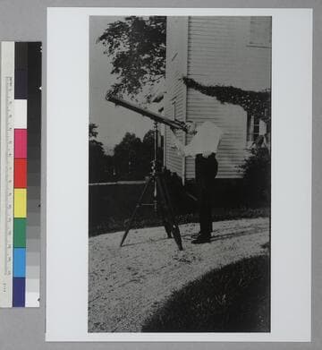 Young Edwin Powell Hubble looking through a telescope