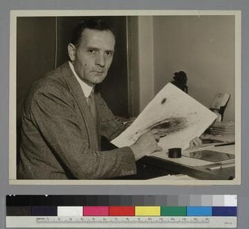 Edwin Powell Hubble, holding a photograph of a galaxy