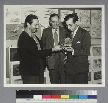Walt Disney, Edwin Powell Hubble and Julian Huxley looking at a dinosaur model