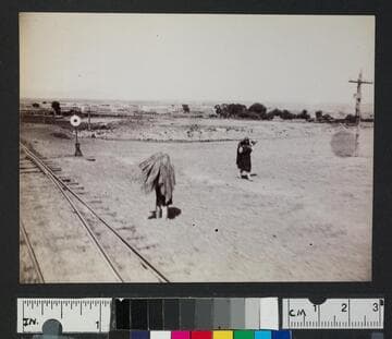 Native American women walking along railroad tracks