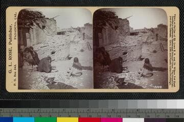 A Hopi woman working with corn in a pueblo