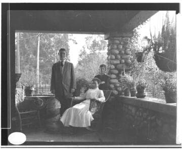 A woman, a teen-age boy, and a young boy on a porch