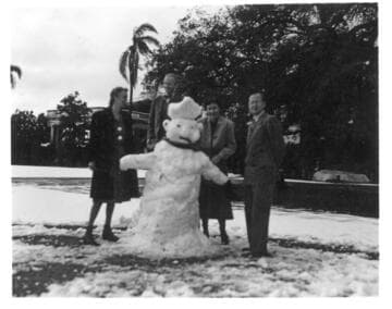 Huntington employees stand around a snowman, January 11, 1949