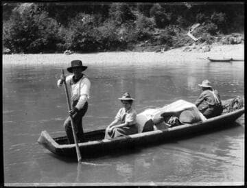 Grace Nicholson sitting in canoe, with Frank Ruben (Karok) paddling, on the Klamath River