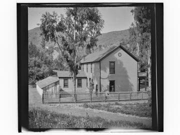 Unidentified two-story house with fenced yard
