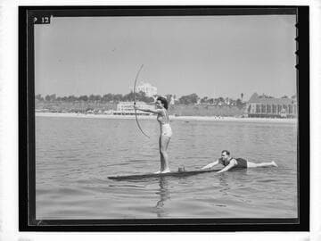 Woman in archery pose on paddle board at Santa Monica