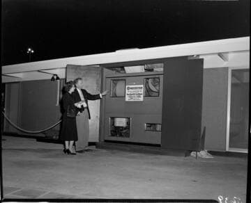 Man and woman looking at a Weatherton Air Conditioning unit ("heats without flame