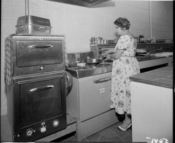Woman cooking on electric range in a commercial kitchen