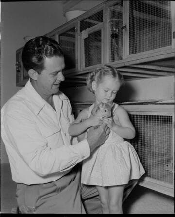 Man with his little daughter holding a chinchilla