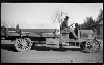 Two men in large flat-bed truck