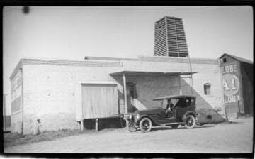 Touring car next to ice plant
