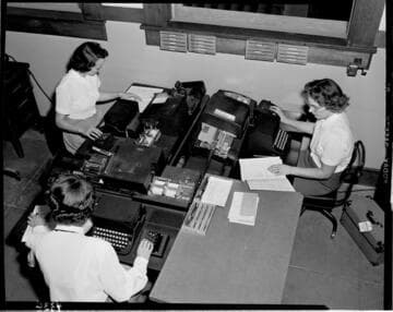 Overhead shot of three computer key punch operators creating data entry cards