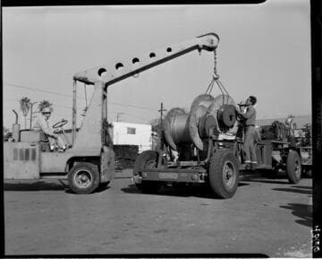 Loading conductor spools onto trailer with small crane