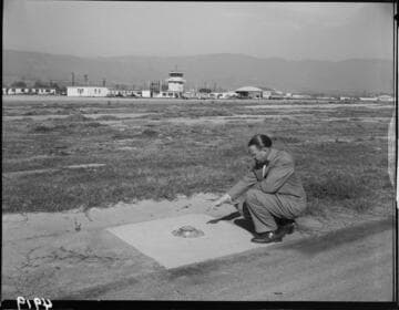 Man pointing to airport runway light