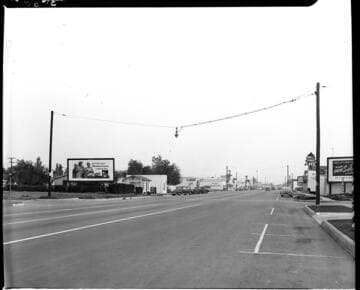 downtown street during the day with suspended street lighting down center