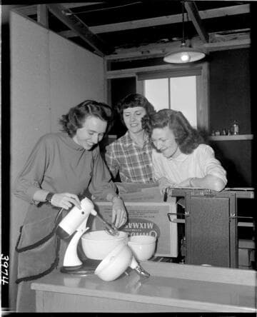 Three women looking at electric mixer