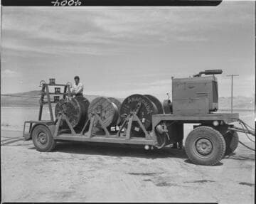 Men running conductor pulling machine
