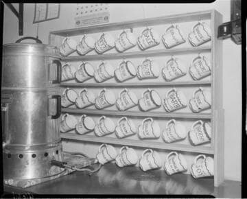 Large coffee maker with rack of personalized coffee mugs