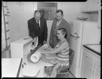 Woman using professional  ironing machine in her home