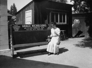 A woman on bench advertising Grace Nicholson's store