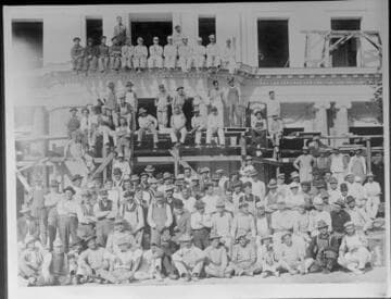 Workers posed in front of the Huntington residence during construction, circa 1910
