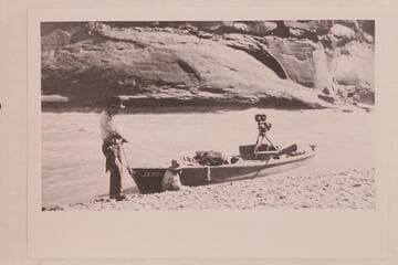 Skiff of Lasky party in small rapid just below Hite.  Jesse Lasky, Jr., and Kenneth Wortley