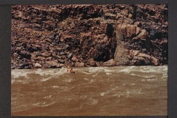 Homer Morgan swimming on air mattress through Bridge Canyon Rapid