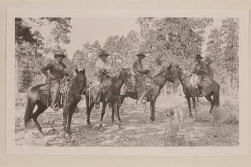 Uncle Jim Owen on mule.  Ammon Davis at right.  The dog in foreground was the leader of Jim's pack.  A brass plate on his collar was inscribed:  My name is Pot Hound.  I have been at the death of 155 lions