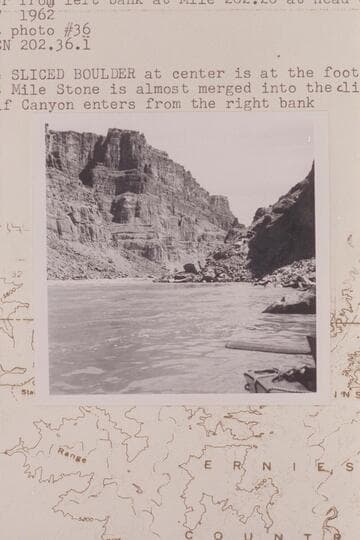 Up river from left bank at Mile 202.20 at head of Rapid #23. The Sliced Boulder at center is at foot of rapid No. 22. 303 Mile Stone is almost merged into cliff in distance. Calf Canyon enters from the right bank